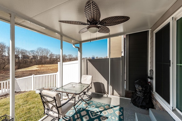 unfurnished sunroom featuring a healthy amount of sunlight and ceiling fan