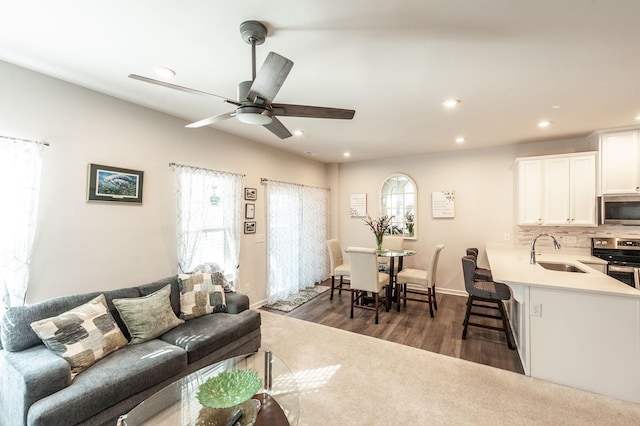 living room with sink, dark wood-type flooring, and ceiling fan