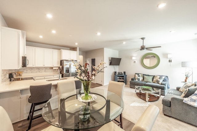 dining area with sink, light hardwood / wood-style floors, and ceiling fan