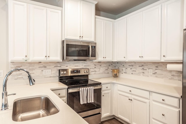 kitchen featuring backsplash, appliances with stainless steel finishes, sink, and white cabinets