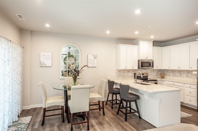 kitchen featuring appliances with stainless steel finishes, sink, white cabinets, and kitchen peninsula