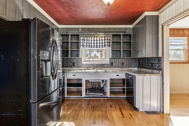 kitchen with light wood-style floors, ornamental molding, a sink, a textured ceiling, and stainless steel fridge with ice dispenser