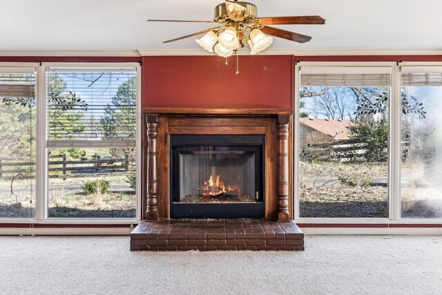 details with crown molding, a fireplace, a ceiling fan, and carpet flooring