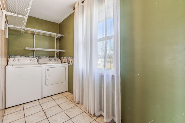 laundry room featuring light tile patterned floors, laundry area, and washing machine and clothes dryer