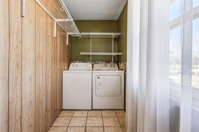 washroom with laundry area, independent washer and dryer, wood walls, and light tile patterned floors