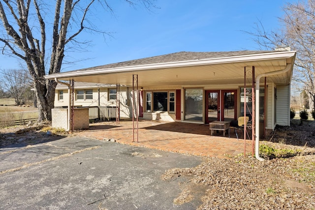 back of property featuring roof with shingles