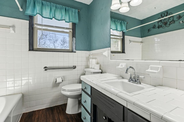 bathroom with a tub to relax in, a shower, toilet, wood finished floors, and vanity