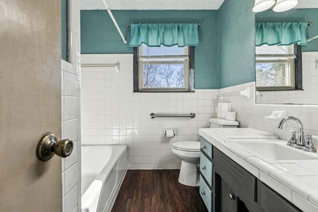 bathroom with tile walls, vanity, toilet, and wood finished floors