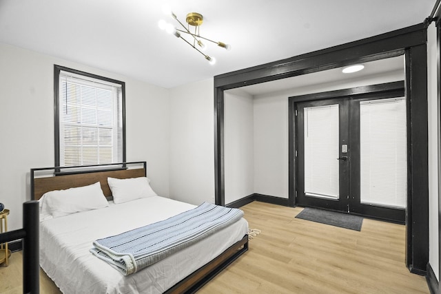 bedroom featuring french doors and light hardwood / wood-style flooring