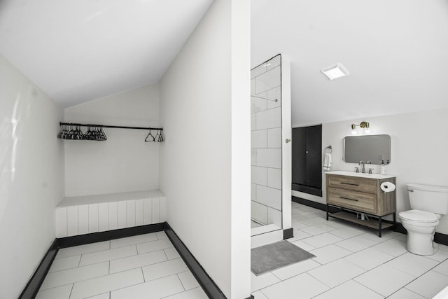 bathroom with lofted ceiling, toilet, a shower, vanity, and tile patterned flooring