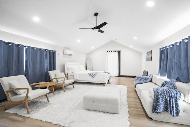 bedroom with ceiling fan, lofted ceiling, a wall mounted AC, and light wood-type flooring