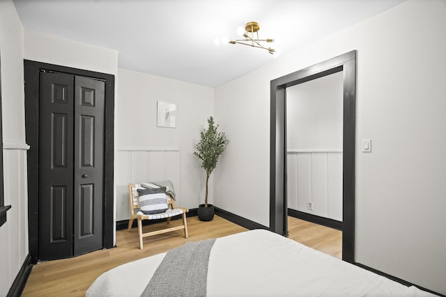 bedroom featuring light hardwood / wood-style flooring, a closet, and a chandelier