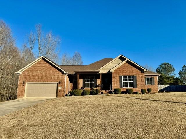 single story home featuring a garage and a front yard