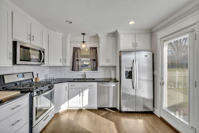 kitchen featuring dark hardwood / wood-style floors, decorative light fixtures, white cabinetry, sink, and stainless steel appliances