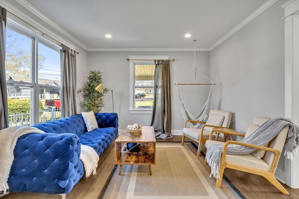 living room with crown molding, hardwood / wood-style flooring, and a wealth of natural light