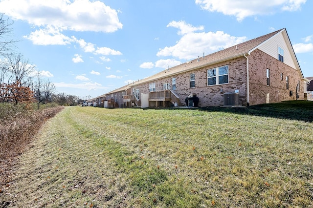 back of house featuring a yard and central AC unit