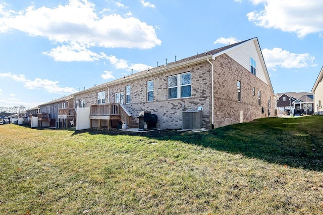 rear view of house featuring central AC and a lawn