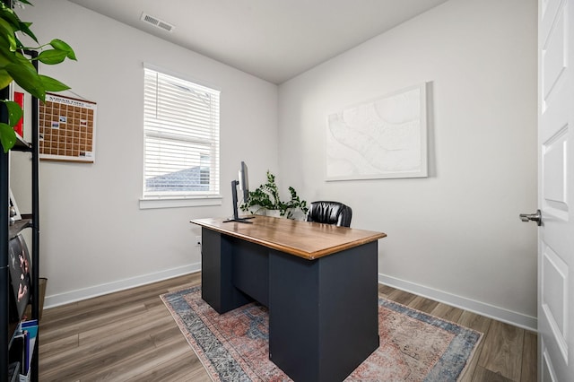 home office with dark hardwood / wood-style flooring