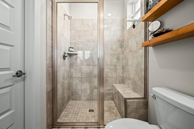 bathroom with a shower with door and toilet