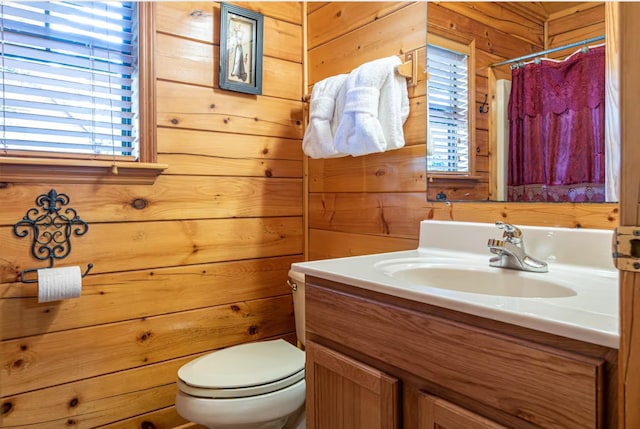 bathroom with plenty of natural light, wooden walls, and vanity