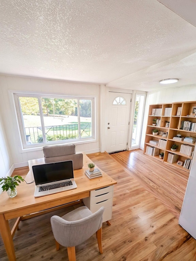 office space with a textured ceiling and light wood-type flooring