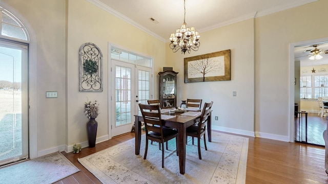 dining room featuring french doors, crown molding, wood finished floors, a chandelier, and baseboards