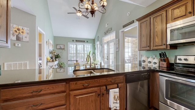 kitchen with visible vents, lofted ceiling, appliances with stainless steel finishes, brown cabinets, and a sink
