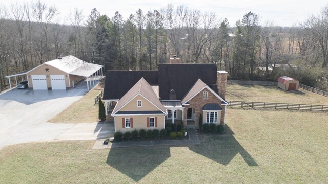 traditional-style home with a garage, a chimney, a front yard, and fence
