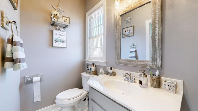 bathroom featuring vanity, toilet, and baseboards