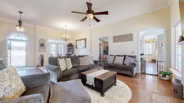 living room featuring light wood-style floors, french doors, a healthy amount of sunlight, and ornamental molding
