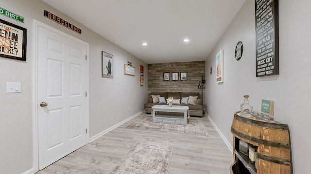 sitting room with recessed lighting, wooden walls, baseboards, and wood finished floors