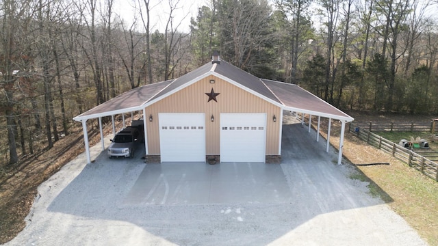 garage featuring a detached garage and fence