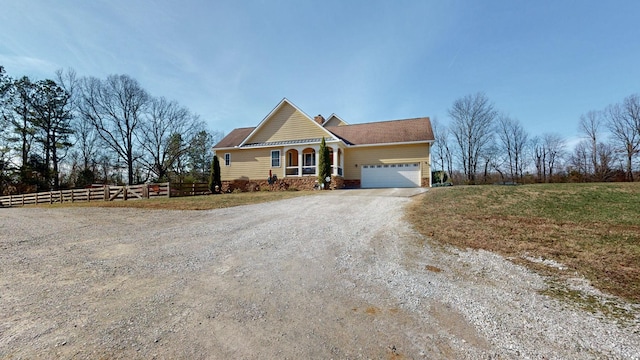 view of front of home featuring a garage, driveway, a front lawn, and fence
