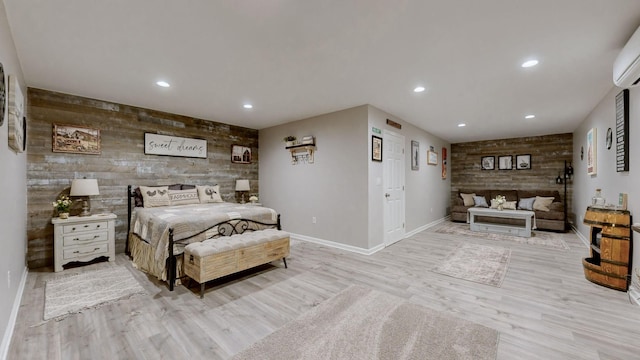 bedroom with baseboards, an accent wall, wood walls, and recessed lighting