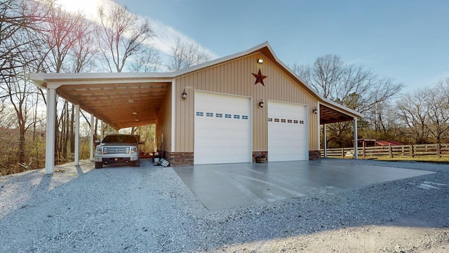 garage with fence, driveway, and a detached garage