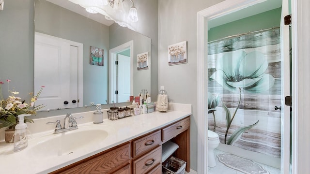 bathroom featuring toilet, an inviting chandelier, curtained shower, and vanity