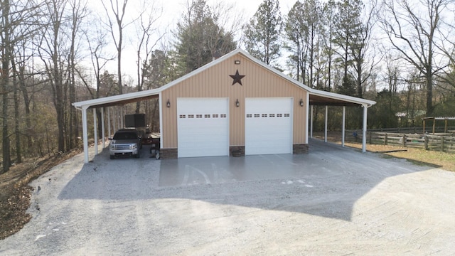 garage with a garage, fence, and driveway