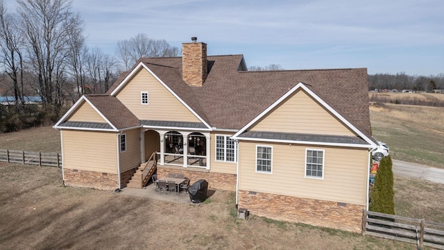 view of front facade featuring a shingled roof, crawl space, a chimney, and fence