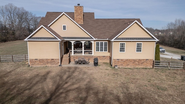 rear view of house featuring a yard, crawl space, a chimney, and fence