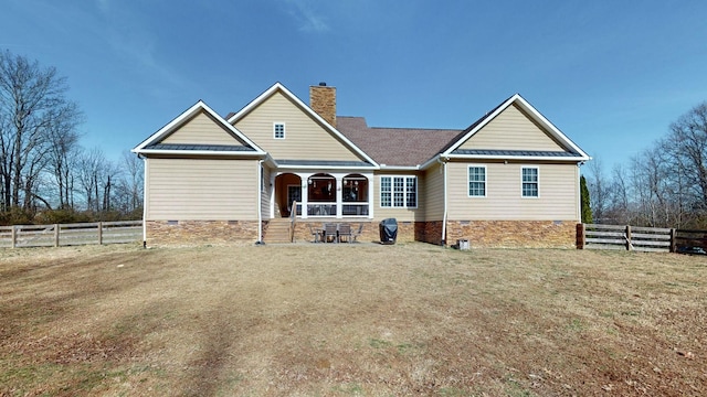 back of property with crawl space, metal roof, a chimney, and a standing seam roof