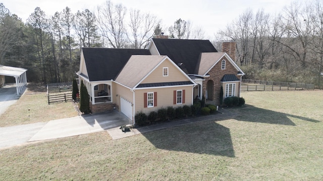 traditional-style home with driveway, a chimney, an attached garage, fence, and a front yard