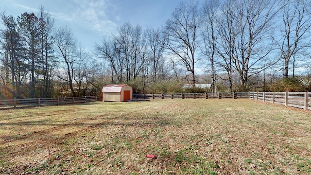 view of yard with a storage shed, a rural view, an outbuilding, and a fenced backyard
