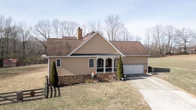 traditional-style house with driveway, a chimney, fence, and a front lawn