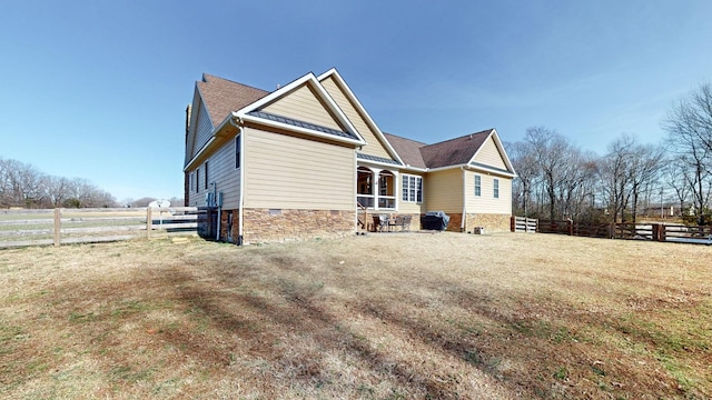 back of property featuring crawl space and fence