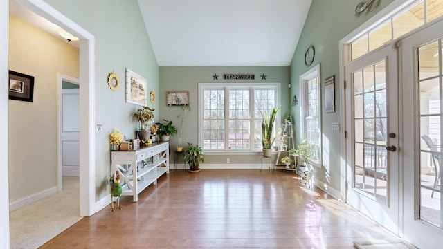 interior space with lofted ceiling, french doors, and baseboards