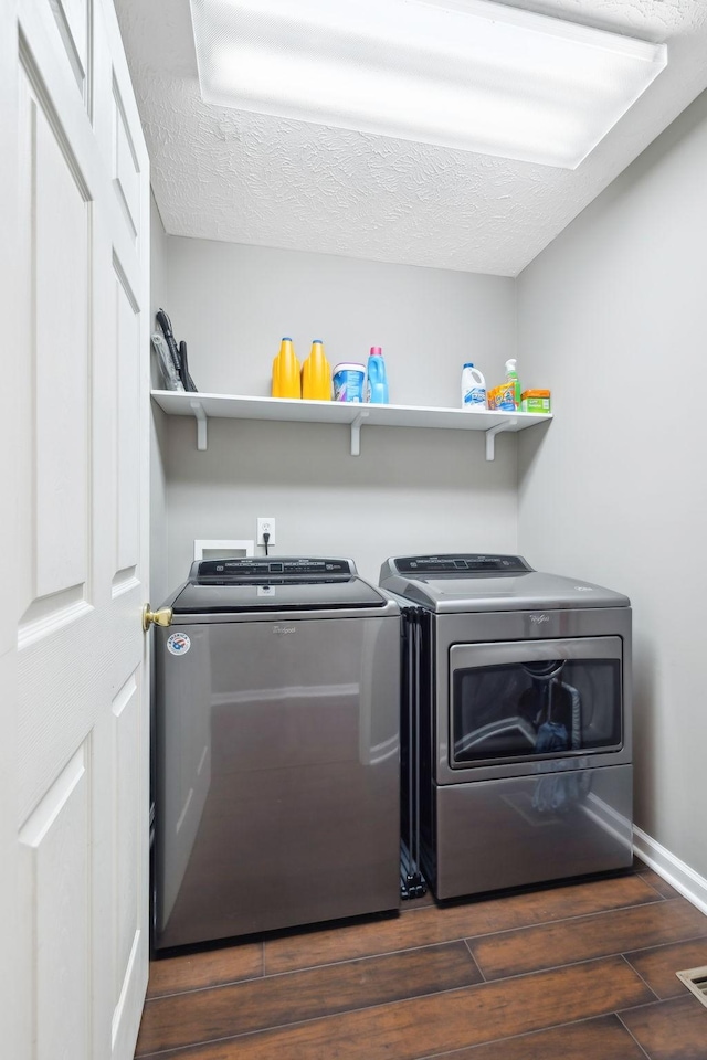 clothes washing area featuring washing machine and dryer and a textured ceiling