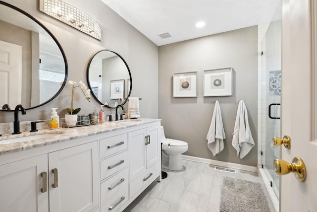 bathroom with vanity, toilet, and a shower with shower door