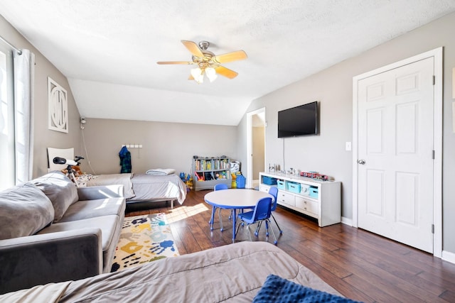 bedroom with ceiling fan, dark hardwood / wood-style flooring, vaulted ceiling, and a textured ceiling