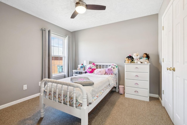 carpeted bedroom with a textured ceiling, a closet, and ceiling fan