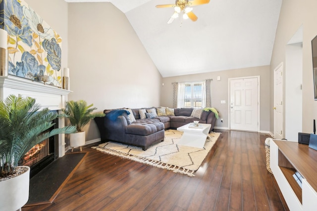 living room featuring dark wood-type flooring, ceiling fan, and vaulted ceiling